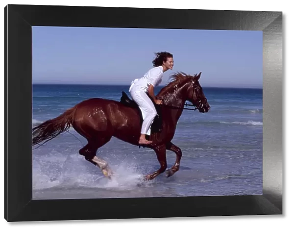 Girl rides HORSE - galloping along sea edge