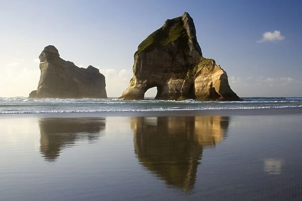 Rocky Islands - by powerful surf sculpted rock islands with caves and arches at Wharariki beach in last evening light Wharariki Beach, Golden Bay, Nelson District, South Island, New Zealand