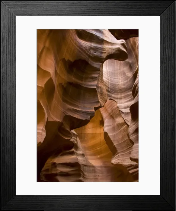 Framed Print : USA - Light that penetrates into the narrow canyon walls creates beautiful hues on the graceful curves of sandstone rock in the Upper Antelope Canyon, probably the most famous slot canyon in the Southwest. Antelope Canyon