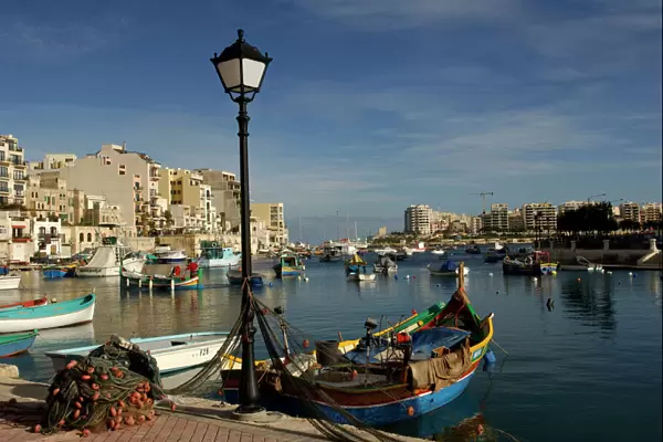 Malta - Spinola Bay - once a thriving fishing port, but in recent years tourism has taken over. The brighly coloured traditional Maltese fishing boats are called 'Luzzu'. November
