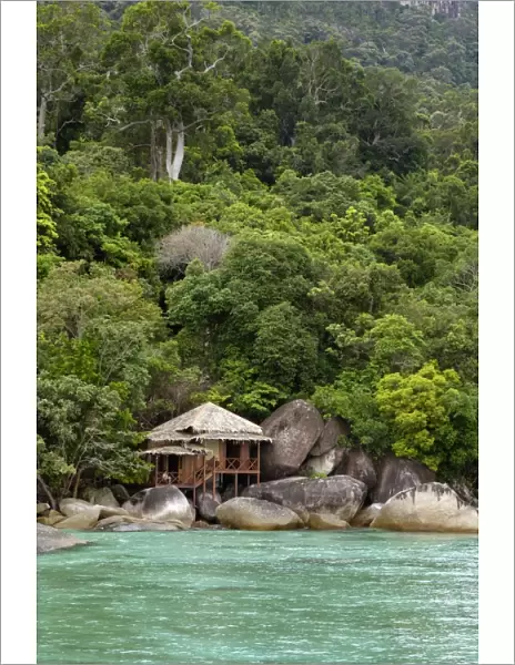 Rainforest and a wooden cabin of the 'Bagus Place Retreat' - a small private resort, on the shore of volcanic Tioman Island (at high tide), 30 km east off peninsula Malaysia in South China Sea; June. Ma39. 3538