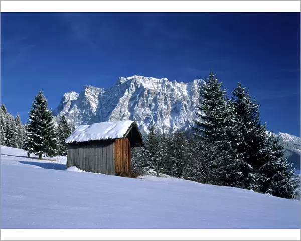 Winter scenery hut and Zugspitze mountain in winter seen from the village of Erwald Erwald, Alps, Austria