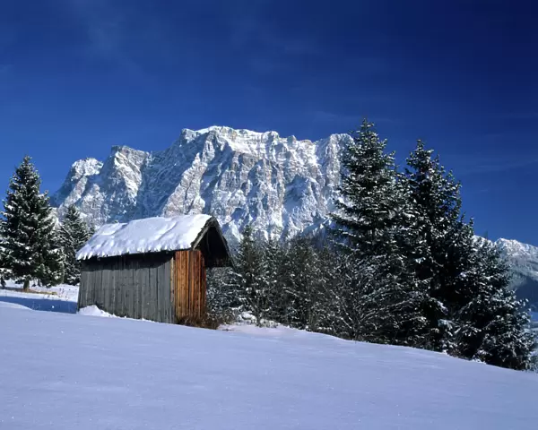 Winter scenery hut and Zugspitze mountain in winter seen from the village of Erwald Erwald, Alps, Austria