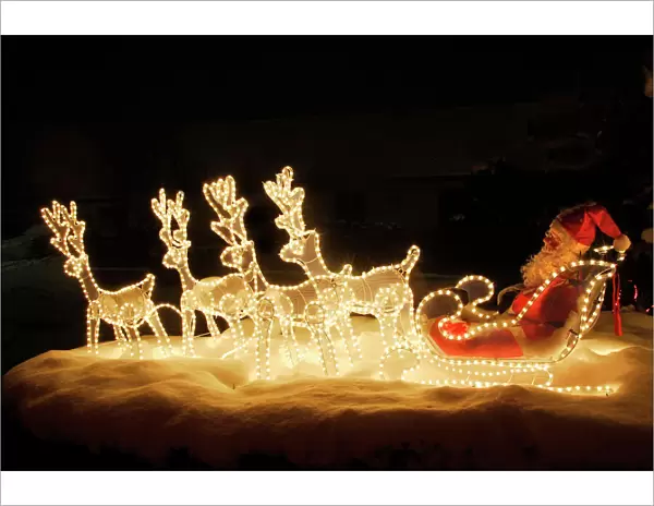 Christmas Decorations - illuminated reindeer & sleigh outside house. France