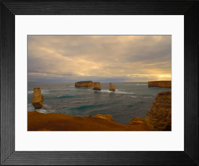 Framed Print : Thunderstorm over the Bay of Islands - dark clouds are gathering over sandstone rock stacks in the Bay of Islands. Through a gap in the dense cloudy canopy the sun sends beams of sunlight onto the raging ocean Framed Print : Thunderstorm over the Bay of Islands - dark clouds are gathering over sandstone rock stacks in the Bay of Islands. Through a gap in the dense cloudy canopy the sun sends beams of sunlight onto the raging ocean