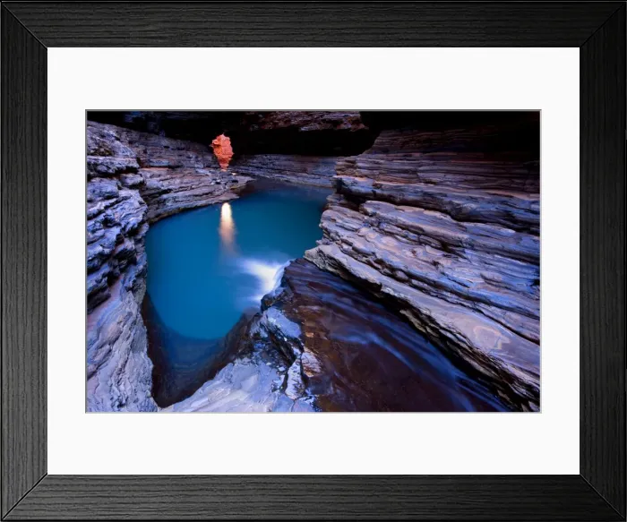Framed Print : Kermit's Pool - a stream is flowing down Hancock Gorge, surrounded by steep, red and very terraced ciffs, into Kermit's Pool. Because of it's depth the pool's water appears an amazing deep blue