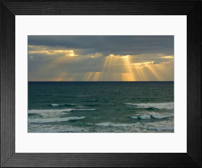 Framed Print : Sunbeams beams of light break through a dense bank of black clouds over the ocean Mangawhai Head, Auckland, North Island, New Zealand Framed Print : Sunbeams beams of light break through a dense bank of black clouds over the ocean Mangawhai Head, Auckland, North Island, New Zealand