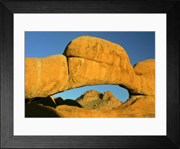 Framed Print : Rock arch ablaze in late evening light framing Spitzkoppe mountain in background Pandok Mountains, Namibia, Africa Framed Print : Rock arch ablaze in late evening light framing Spitzkoppe mountain in background Pandok Mountains, Namibia, Africa