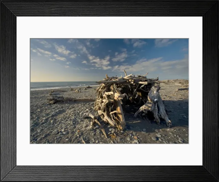 Framed Print : Room with a view simple shelter built of tree trunks and branches on the beach Gillespies Beach, Westland National Park, West Coast, South Island, New Zealand Framed Print : Room with a view simple shelter built of tree trunks and branches on the beach Gillespies Beach, Westland National Park, West Coast, South Island, New Zealand