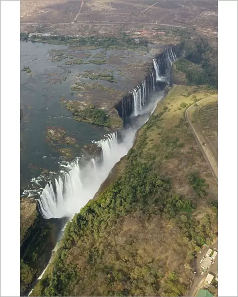 Zimbabwe  /  Zambia - Aerial view of the Zambezi River and the Victoria Falls (1700m wide). In the foreground the Main Falls (93m high, Zimbabwe), in the centre Livingstone Island (borderline Zimbabwe / Zambia), behind the Rainbow Falls (108m)