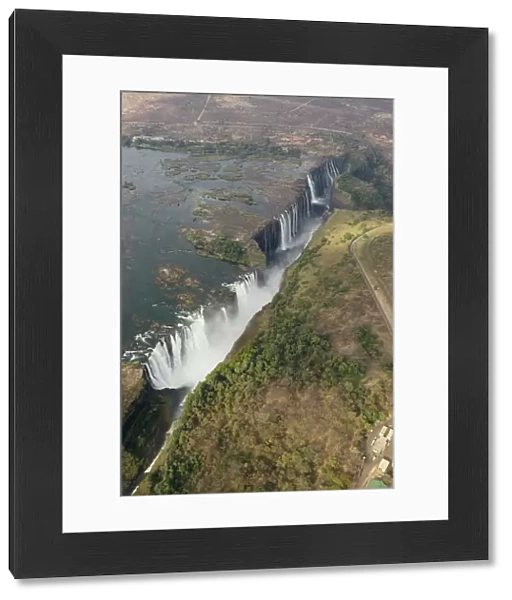 Zimbabwe  /  Zambia - Aerial view of the Zambezi River and the Victoria Falls (1700m wide). In the foreground the Main Falls (93m high, Zimbabwe), in the centre Livingstone Island (borderline Zimbabwe / Zambia), behind the Rainbow Falls (108m)
