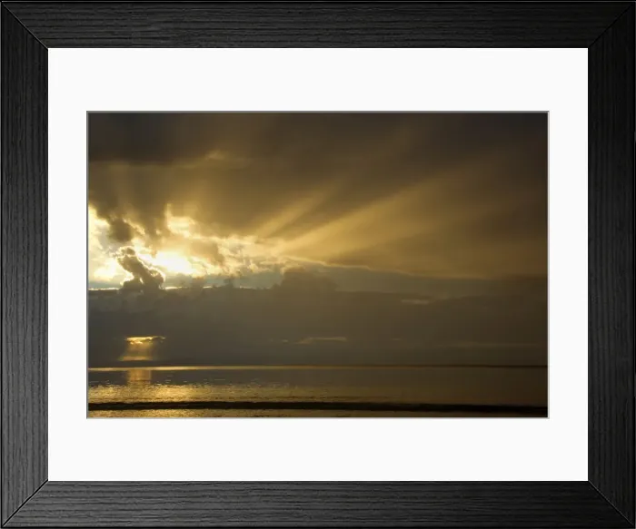 Framed Print : Thunderstorm over the ocean - dark clouds of a thunderstorm are approaching the beach at Oyster Bay. The setting sun is able to breack through gaps in the dense cloud cover and sends orange and yellow sunrays out