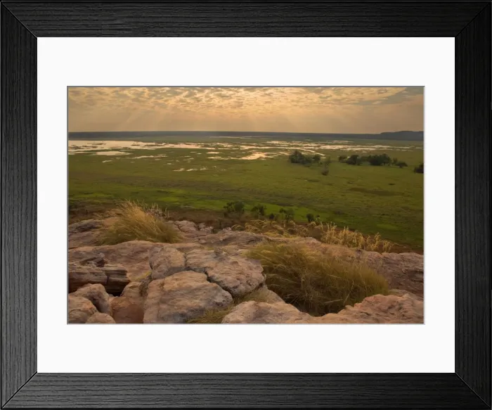 Framed Print : Ubirr view - breathtaking view from Ubirr rock towards the Nardab floodplain. The evening sun is partly hidden behind beautiful clouds and sends sunrays through the open gaps between the clouds Framed Print : Ubirr view - breathtaking view from Ubirr rock towards the Nardab floodplain. The evening sun is partly hidden behind beautiful clouds and sends sunrays through the open gaps between the clouds