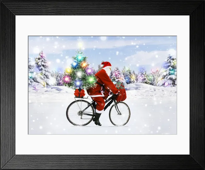 Framed Print : 13132615. Father Christmas riding bicycle through winter snow scene Date Framed Print : 13132615. Father Christmas riding bicycle through winter snow scene Date