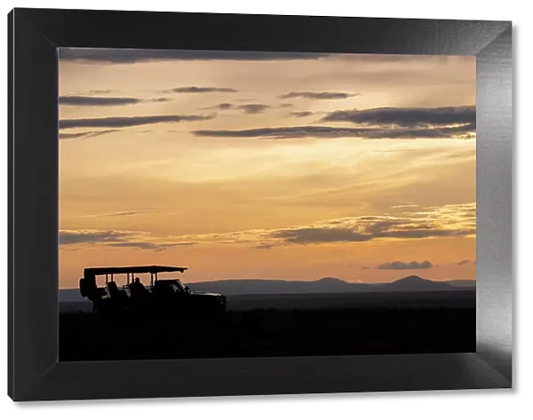 Africa, Kenya, Northern Serengeti Plains, Maasai Mara. Mara sunrise with safari jeep silhouette. Date: 30-10-2020