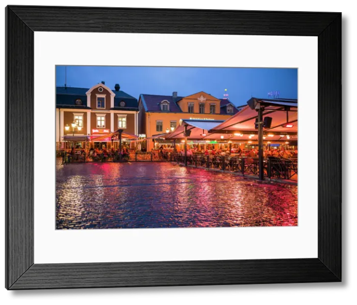 Framed Print : Sweden, Linkoping, cafes and bars on Stora target square, dusk Date: 18-05-2019 Framed Print : Sweden, Linkoping, cafes and bars on Stora target square, dusk Date: 18-05-2019