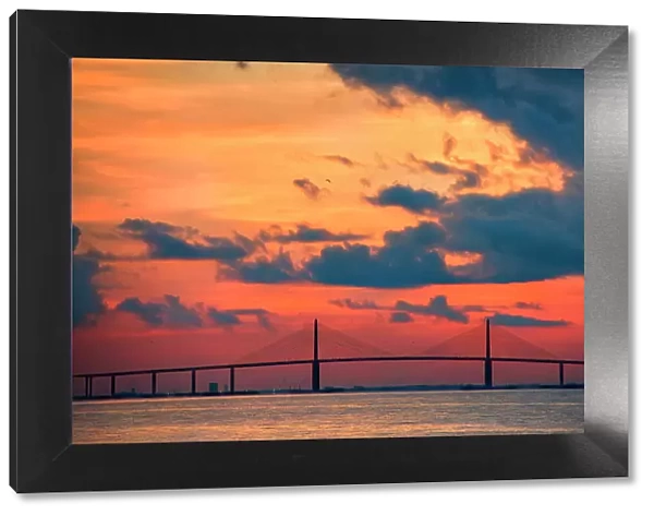 The Skyway Bridge over the Gulf of Mexico with the reds and oranges of the sunrise in the sky. Date: 26-07-2014