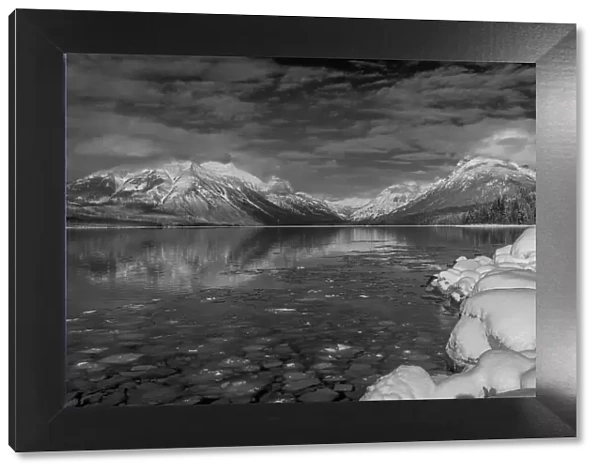 Mountains reflect in wintry Lake McDonald in Glacier National Park, Montana, USA Date: 17-02-2021