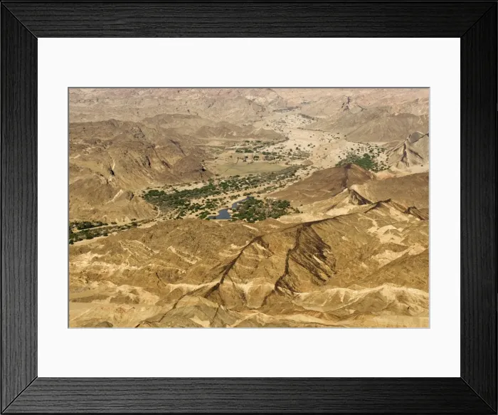 Framed Print : Black dolerite dykes spread through the Moon Valley Landscape - The Swakop River with its green foliage leads off into the distance - Namib Desert - Namibia - Africa Framed Print : Black dolerite dykes spread through the Moon Valley Landscape - The Swakop River with its green foliage leads off into the distance - Namib Desert - Namibia - Africa