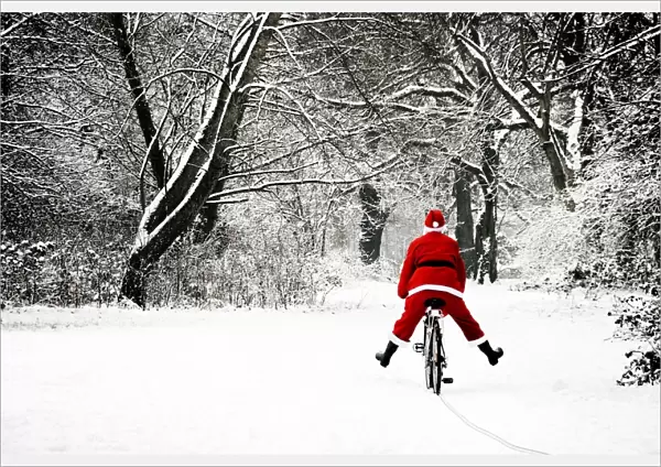 Father Christmas - in snow - on bicycle freewheeling