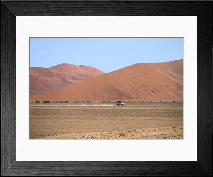 Framed Print : Namibia - a landrover drives through the valley at Sossusvlei flanked by mountainous dunes Framed Print : Namibia - a landrover drives through the valley at Sossusvlei flanked by mountainous dunes