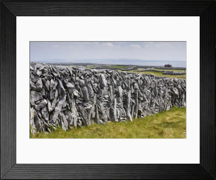 Framed Print : Old limestone drystone wall on Inisheer with small fields and the wreck of the Plassey beyond; the Burren, western Eire Framed Print : Old limestone drystone wall on Inisheer with small fields and the wreck of the Plassey beyond; the Burren, western Eire