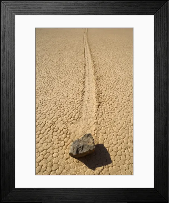 Framed Print : The Racetrack - mysterious sliding rocks of the famous Racetrack Playa - a dried up lake bed which is nestled between the Cottonwood Mountains and the Last Chance Range - furrows in the dried mud indicate that these boulders - some of them weighing Framed Print : The Racetrack - mysterious sliding rocks of the famous Racetrack Playa - a dried up lake bed which is nestled between the Cottonwood Mountains and the Last Chance Range - furrows in the dried mud indicate that these boulders - some of them weighing