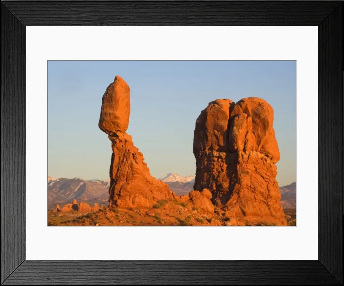 Framed Print : Balanced rock - sandstone rock formation in the shape of a spire with an oval shaped rock balanching on top of it. The snow covered Manti-La Sal Mountains and the Windows Section of the park with its numerous arches is visible in the background Framed Print : Balanced rock - sandstone rock formation in the shape of a spire with an oval shaped rock balanching on top of it. The snow covered Manti-La Sal Mountains and the Windows Section of the park with its numerous arches is visible in the background