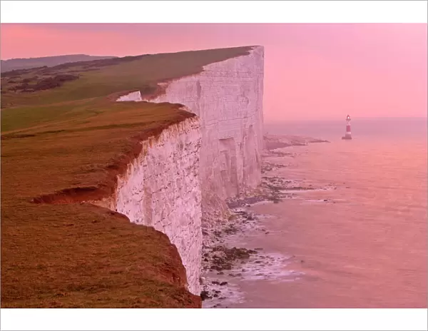 UK - lighthouse at Beachy Head and steep chalk cliffs at sunrise. East Sussex, England, UK