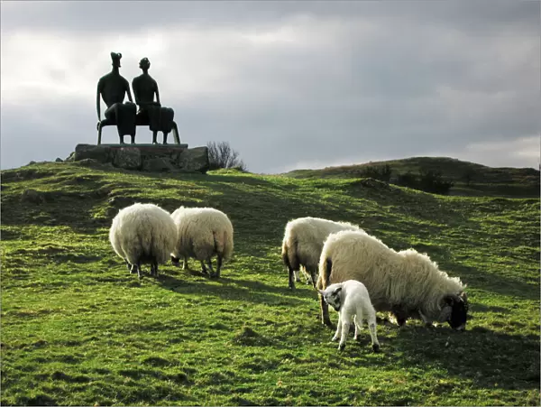 Sheep - grazing before the Henry Moore sculpture King & Queen Glenkiln Estate Sculpture Park, overlooking the Glenkiln reservoir, Dumfries Scotland