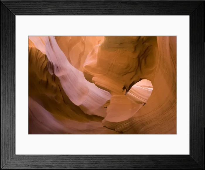 Framed Print : USA - Light that penetrates into the narrow canyon walls creates beautiful hues on the graceful curves of sandstone rock in the Lower Antelope Canyon, probably the most famous slot canyon in the Southwest. Antelope Canyon
