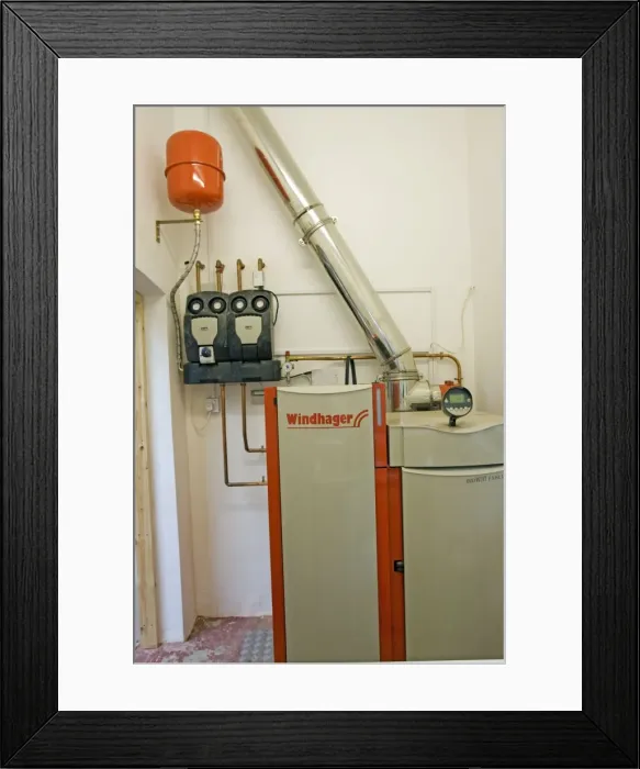 Framed Print : Bolier - Windhager Austrian wood pellet fired domestic biomass boiler produces heat for thermal store using small wood pellets supplied from a large external hopper installed in small cottage Cotswolds UK Framed Print : Bolier - Windhager Austrian wood pellet fired domestic biomass boiler produces heat for thermal store using small wood pellets supplied from a large external hopper installed in small cottage Cotswolds UK