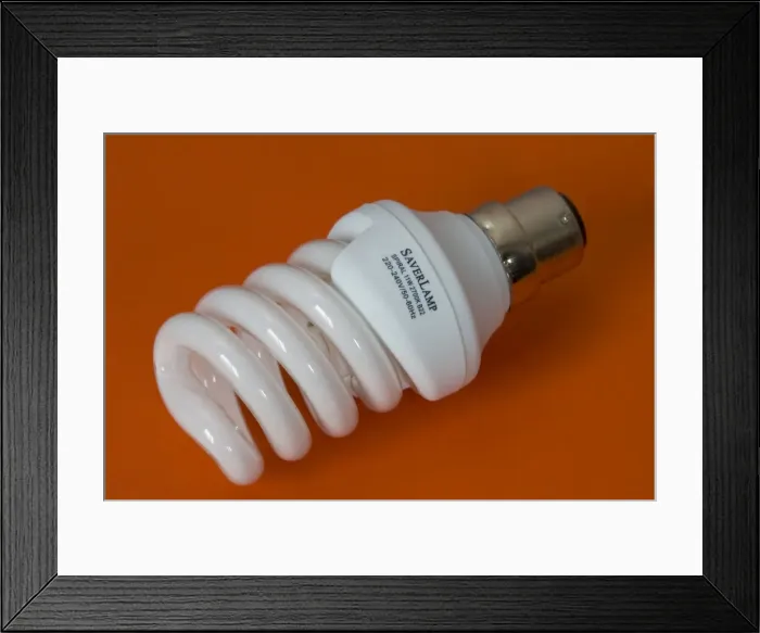 Framed Print : Energy efficient light bulb or Saverlamp, UK - Compact fluorescent energy efficient spiral light bulb or Saverlamp uses 80% less energy than traditional bulbs and last up to 10 times longer, UK