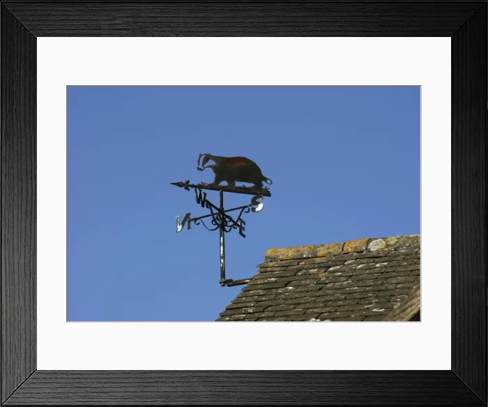 Framed Print : Wind / weather vane - wrought iron with badger figure against blue sky Cotswolds, UK Framed Print : Wind / weather vane - wrought iron with badger figure against blue sky Cotswolds, UK