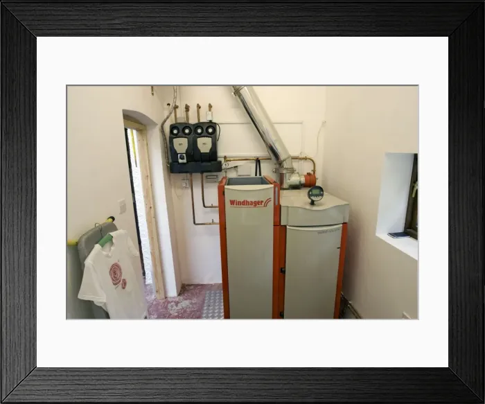 Framed Print : Windhager Austrian wood pellet fired domestic biomass boiler produces heat for thermal store using small wood pellets supplied from a large external hopper installed in small cottage Cotswolds UK Framed Print : Windhager Austrian wood pellet fired domestic biomass boiler produces heat for thermal store using small wood pellets supplied from a large external hopper installed in small cottage Cotswolds UK