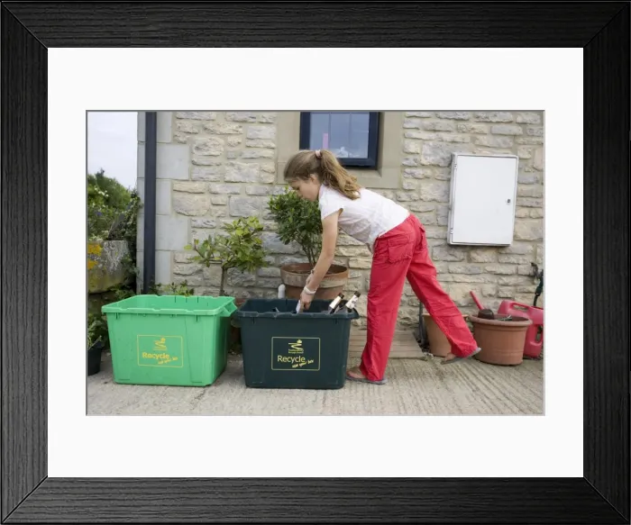 Framed Print : Recycling - Young girl putting empty bottles in green bin Cotswolds UK Model released Framed Print : Recycling - Young girl putting empty bottles in green bin Cotswolds UK Model released