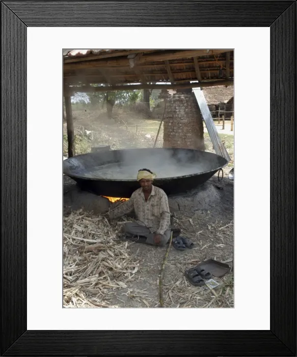Framed Print : Worker - Sugar factory, India. Shows boiling pan in which sugar solution is evapourated to form syrup, using crushed cane as the fuel