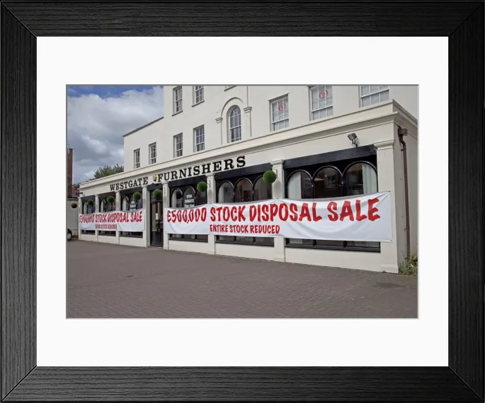Framed Print : Sale notices in furnishing shop window offering big discounts - Cheltenham UK Framed Print : Sale notices in furnishing shop window offering big discounts - Cheltenham UK