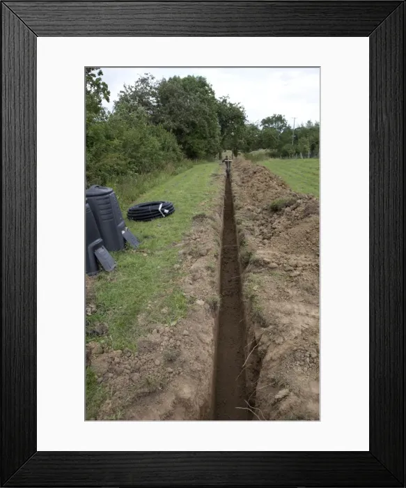 Framed Print : Trench dug out in field to carry electric cable ducting - Cotswolds - UK Framed Print : Trench dug out in field to carry electric cable ducting - Cotswolds - UK