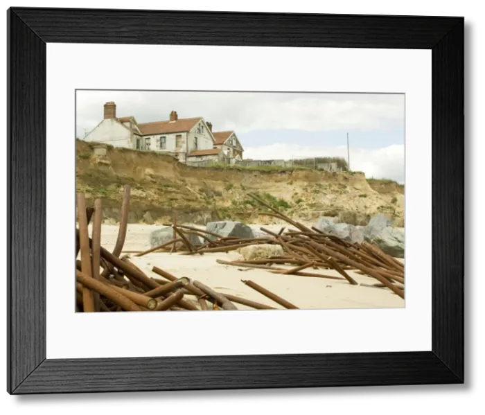 Framed Print : Houses on cliff edge and remains old sea defences after severe coastal erosion Happisburgh North Norfolk Coast UK Framed Print : Houses on cliff edge and remains old sea defences after severe coastal erosion Happisburgh North Norfolk Coast UK