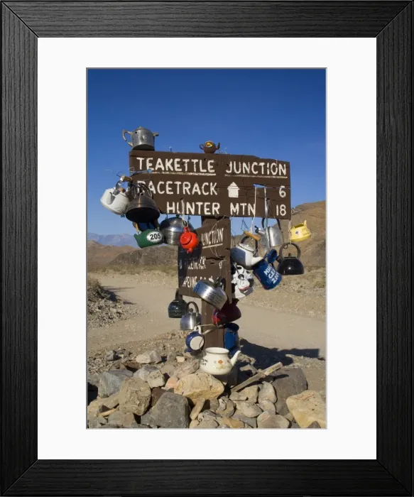 Framed Print : Teakettle Junction - wooden road sign at Teakettle Junction, decorated with funny colourful teakettles left by travellers and tourists. On the way to The Racetrack - Death Valley National Park, California, USA Framed Print : Teakettle Junction - wooden road sign at Teakettle Junction, decorated with funny colourful teakettles left by travellers and tourists. On the way to The Racetrack - Death Valley National Park, California, USA