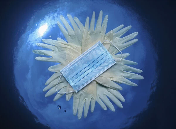 13132602. Concept image depicting the ocean pollution by plastic gloves