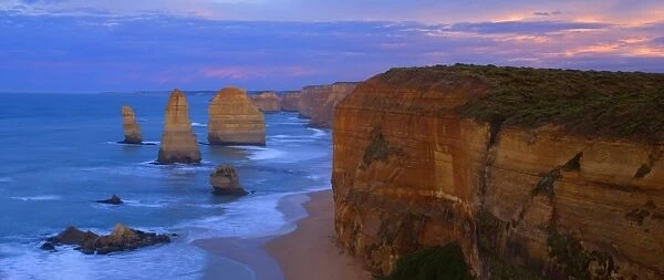 Twelve Apostles sunset - sandstone rock formations of famous Twelve Apostels, which are sculpted by the relentless sea, just before sunrise. The force of the sea eats more and more of the rocks away and finally forces them to collapse