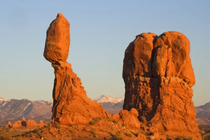 Framed Print : Balanced rock - sandstone rock formation in the shape of a spire with an oval shaped rock balanching on top of it. The snow covered Manti-La Sal Mountains and the Windows Section of the park with its numerous arches is visible in the background Framed Print : Balanced rock - sandstone rock formation in the shape of a spire with an oval shaped rock balanching on top of it. The snow covered Manti-La Sal Mountains and the Windows Section of the park with its numerous arches is visible in the background