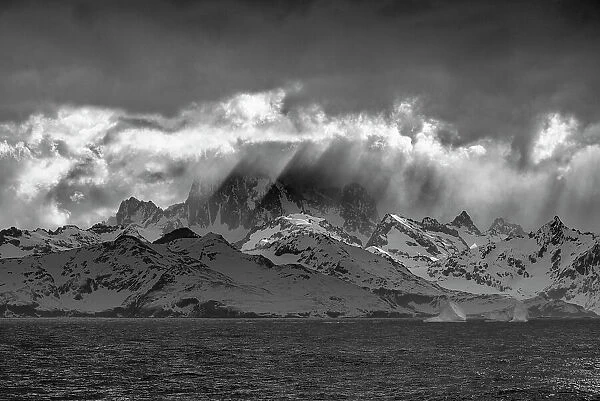 Black and white of South Georgia Island. Opening in clouds and Virga reveal the mountainous and glaciated landscape. Date: 18-10-2019