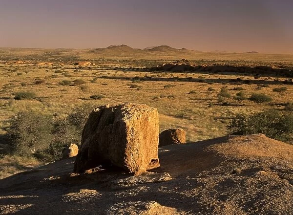 Boulder and savanna in late evening light at the Pandok mountain area Pandok mountains, Namibia