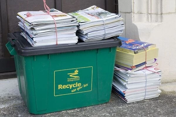Bundles of magazines and newspapers neatly tied and left for recycling on green bin Cotswolds UK