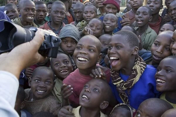 Children looking at photo of themselves in tourist's camera