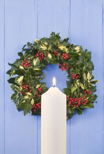 Christmas Wreath on old wooden door with white candle
