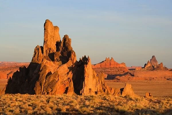 Church Rock - sandstone formation called Church Rock, Comb Ridge in the middle and Agathla Peak in the background in late evening light - Navajo Reservation near Kayenta, Arizona, USA